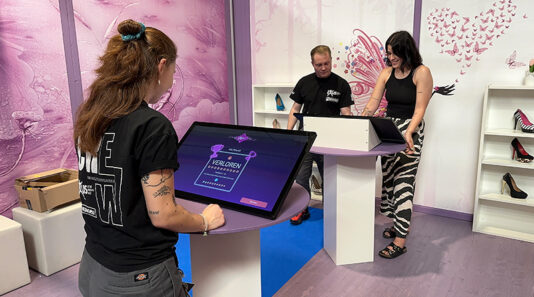 Zwei Teams duellieren sich in Quizbattle vor einem Screen